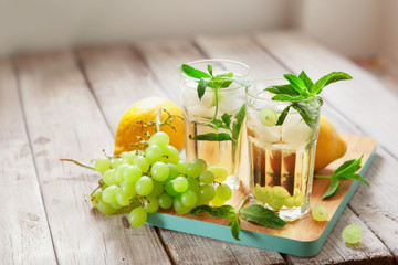 Glass of grape juice with ice on wooden table