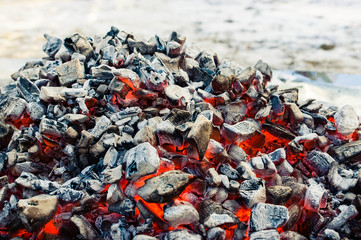 a pile of glowing coals at daylight