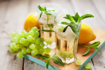 Glass of grape juice with ice on wooden table