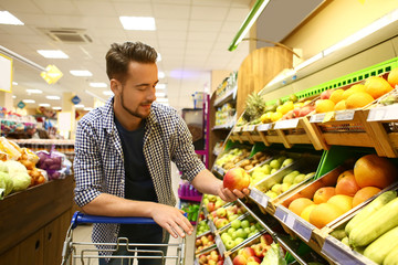 Young man choosing food in supermarket