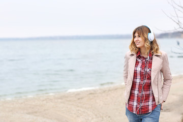 Beautiful woman listening to music near river
