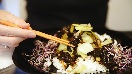 Eating chinese rice dish with sticks
