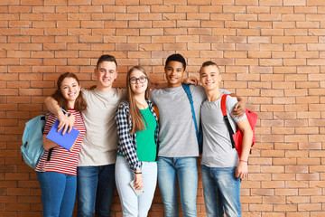 Group of teenagers near brick wall