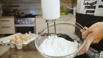 Fototapeta na wymiar Cook making a cream from egg whites