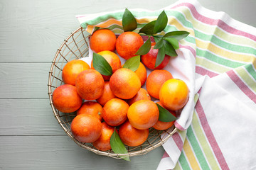 Basket with fresh blood oranges on wooden table