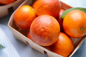 Box with fresh blood oranges on table