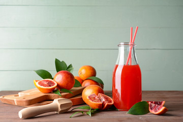 Bottle of fresh blood orange juice on wooden table