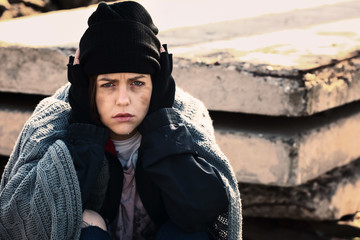 Portrait of sad homeless woman outdoors