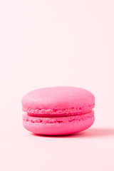 bright macaron cookie with filling on pink surface