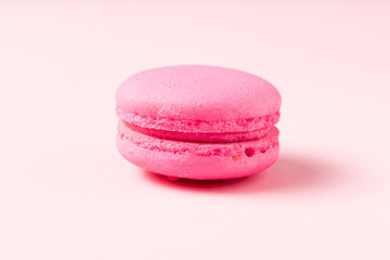 bright macaron cookie with filling on pink surface