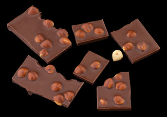 milk chocolate pieces with nuts on a dark background