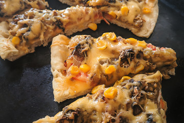 homemade pizza with cheese, sweet corn, vegetables. on the baking sheet.