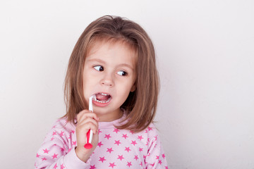 Cute little girl brushing her teeth