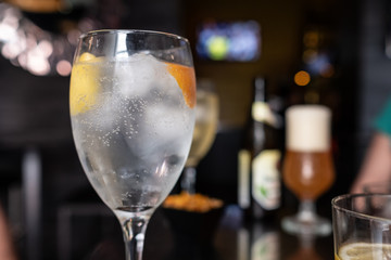 vodka glass with lemon and orange slice in cocktail bar