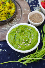 Green spinach dip sauce paste spread in bowl with sunflower seeds, oil and cumin. Organic healthy food snack or appetizer 