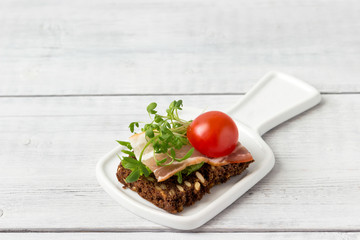 Sandwich with bacon, tomato and herbs  sprouts.