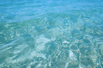Transparent clean sunny ocean sea water waves for background and texture.