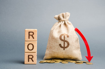 Wooden blocks with the word ROR, money bag and down arrow. Financial ratio illustrating the level...