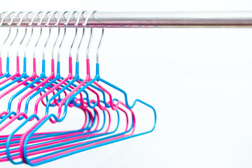 Empty hangers on a white background. The concept of nothing to wear, no clothes. It's time for shopping. Multicolored bright hangers fashionable colors. Fashion style and discounts.