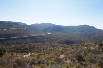 Old highway road on a sunny summer tropical island near mountains and green hills for background.