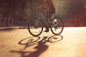 Fototapeta na wymiar Girl Kid Riding Bike in Summer in City at Beautiful Sunset 