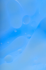 Blurred abstract background. Blue and light blue circles and wavy lines of different sizes. Cropped shot, vertical, a lot of free space, nobody. Concept of design.