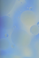 Blurred abstract background. Blue and light blue circles and wavy lines of different sizes on a gray background. Cropped shot, vertical, a lot of free space, nobody. Concept of design.