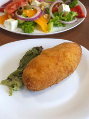chicken kiev and salad on table