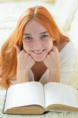 a young woman is reading a book