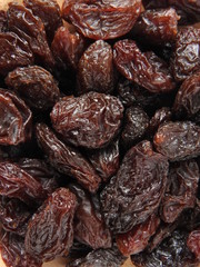 Top view of dried raisins background. Dry food. It tastes sweet and delicious. Raisins are usually eaten as snacks or added to pastries or biscuit. Texture detail of raisin surface. Food concept