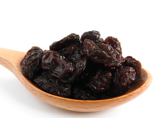 High angle view of raisins on wooden spoon isolated on white background. A raisin is a dried grape Dry food. It tastes sweet and delicious. Texture detail of raisin surface. Food concept.