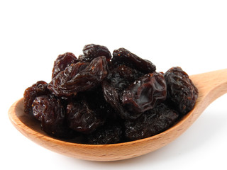 High angle view of raisins on wooden spoon isolated on white background. A raisin is a dried grape Dry food. It tastes sweet and delicious. Texture detail of raisin surface. Food concept.
