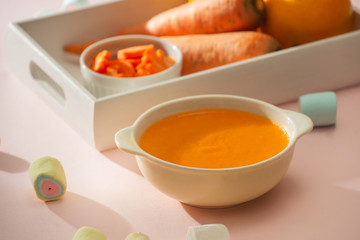 Carrot baby puree in bowl isolated on light background