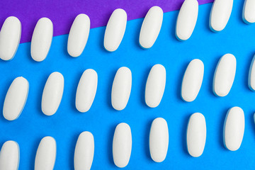 Chaotically scattered white pills on a blue background pattern. White pills background. Texture for design