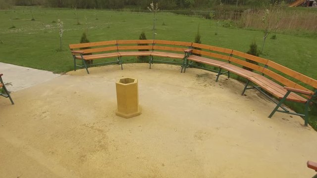 Green courtyard with open gazebo, benches and thujas