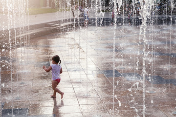 little girl running in the fountain