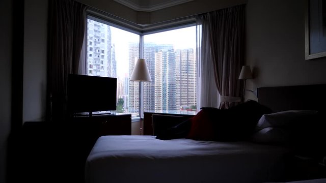 Woman feel down and lie on bed, silhouetted shot, bright window in dark room. Lady in black suit and red skirt become sad, come to rest alone at bedroom