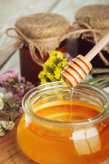 Honey background. Sweet honey in glass jar on wooden background.