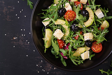Green salad with sliced avocado, cherry tomatoes, black olives and cheese. Healthy diet vegetarian summer vegetable salad. Table setting. Food concept. Top view.
