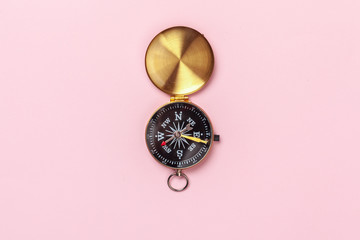 Compass on pink background, top view