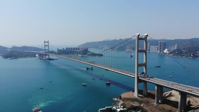 Long suspension bridge construction span across wide channel. Aerial shot of Tsing Ma bridge, light traffic on Lantau Link highway. Modern transportation network at Hong Kong megalopolis