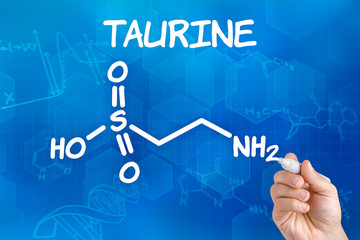 Hand with pen drawing the chemical formula of taurine
