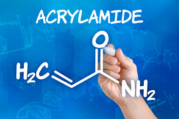 Hand with pen drawing the chemical formula of acrylamide
