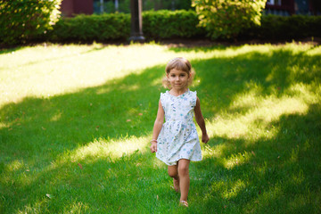 Naklejka premium Sweet little girl outdoors with curly hair in the wind.