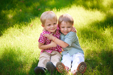 Portrait of two boys embracing and laughing outdoors