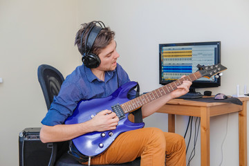 A man in headphones playing guitar.