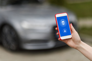 Mockup image of woman holding mobile phone with blank screen. Business woman using phone on car background.