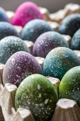 Boiled Easter eggs painted in the style of cosmos and a distant galaxy, against the backdrop of an antique tree and a beautiful flower. Easter.