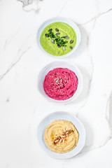 Flat-lay of  beetroot, spinach and classic humus dips, top view. Superfood, clean eating, dieting food concept