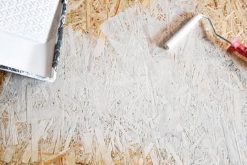 osb plate painted with white paint with a roller